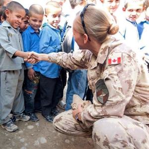 Female Canadian Forces Soldier speaking with children in Afghanistan